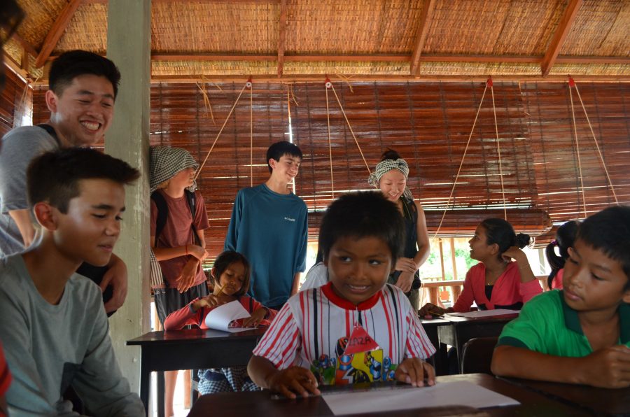 Maya Hinkin 18 and William Park 17 (second and third from left) sit in on an art class with Cambodian studnet and their teacher. Credit Tarin North (used with permission)