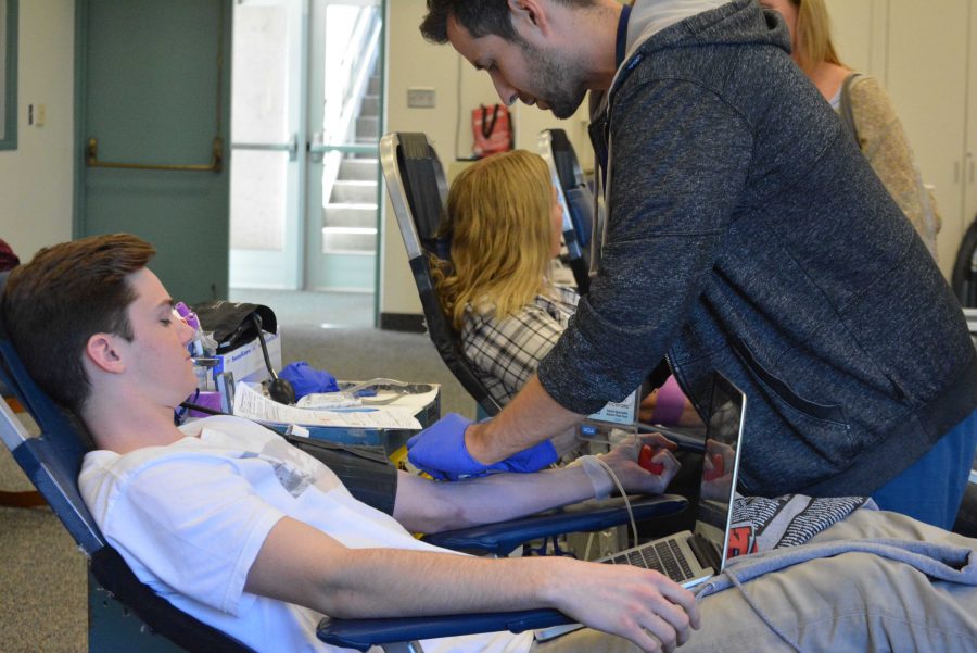 Alec Winshel 16 gives blood at the blood drive Friday. Credit: Tiffany Kim/Chronicle