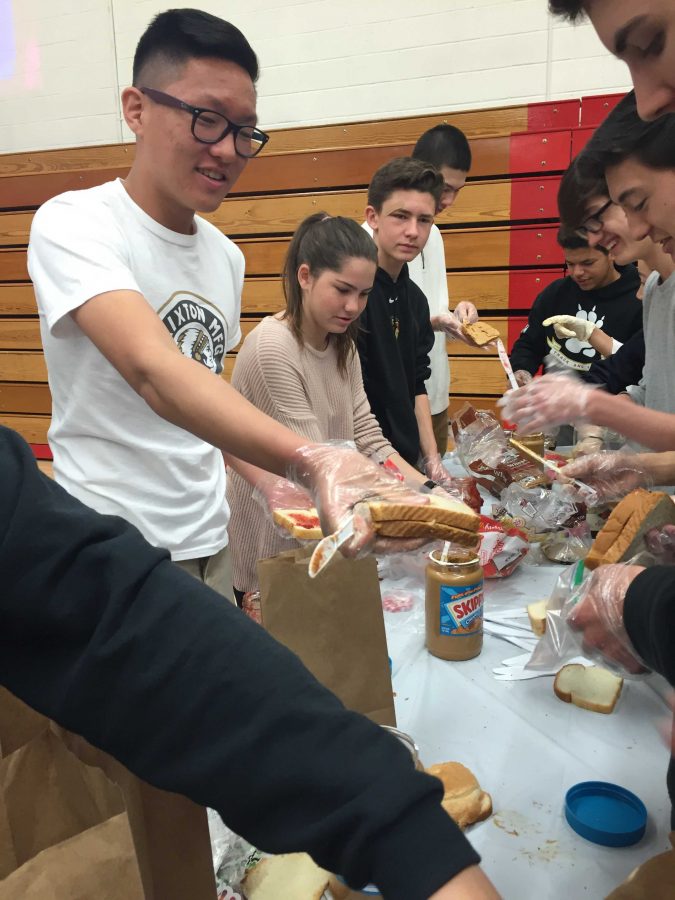 Sean Yang 18 makes a sandwich for a sack lunch that will be donated to the North Hollywood Interfaith Food Pantry. Credit: Danielle Spitz/Chronicle