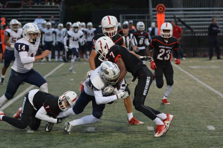 Max Robertson '17 tackles a Garfield player during the Wolverines' 31-38 loss on Sept. 9.  Credit: Cameron Stine/ Chronicle