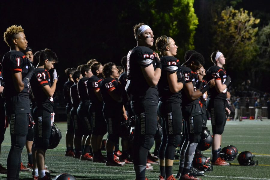 Liam Douglass 18 and the football team looks on during the playing of the national anthem. Credit: Aaron Park/Chronicle