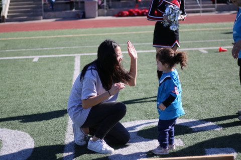 Carolyn Kim '18 high-fives a preschooler taking part in a Special Olympics event Dec. 2. Credit: Pavan Tauh/Chronicle
