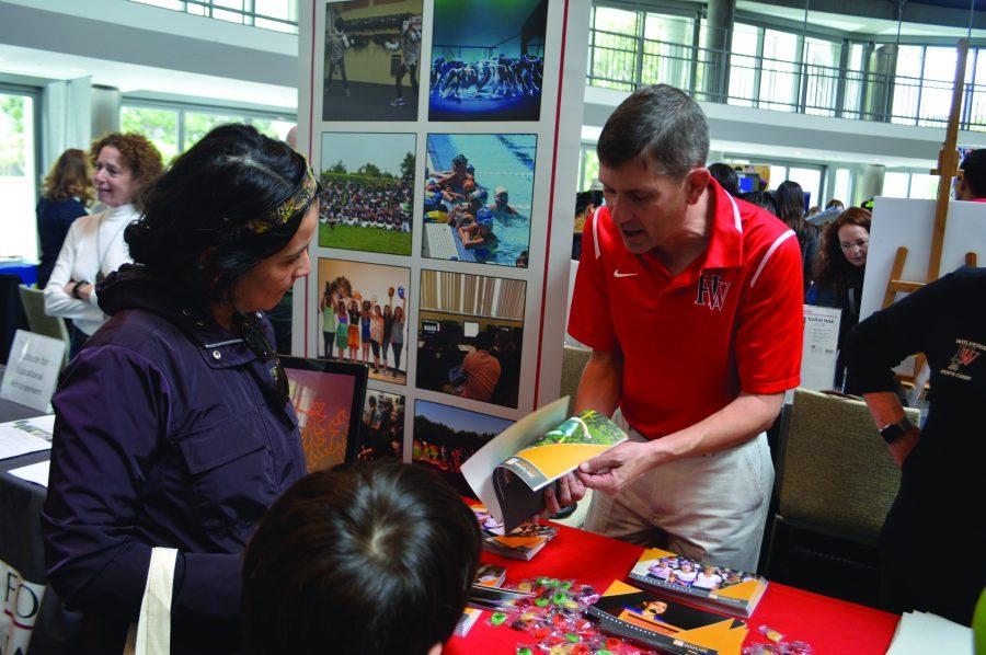 Director of Kutler Center and Summer Programs Jim Patterson works at the schools booth at the Summer Days CAMP Fair to promote summer programs to prospective families. Credit: Jenny Li/Chronicle