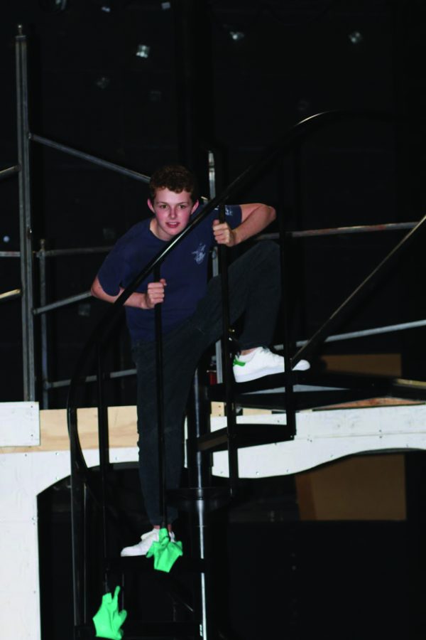 Jake Schroder 20 leans over a staircase on set during rehearsal. Credit: Pavan Tauh/Chronicle