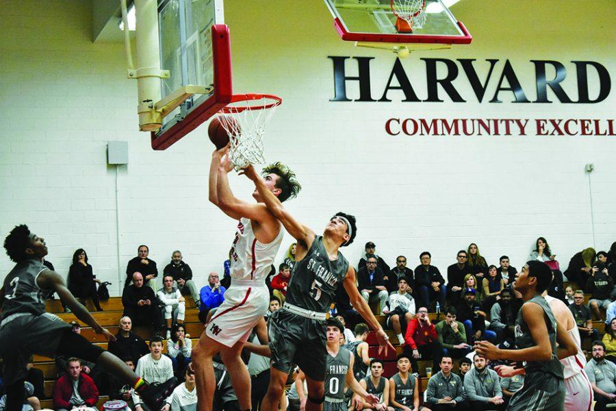 Forward Truman Gettings ’21 drives for a layup against a St. Francis defender in Taper Gymnasium Jan 19. The Wolverines, propelled by 29 points and 16 rebounds from 6-foot-10 forward Mason Hooks ’20, defeated the Golden Knights 69-64. The squad finished the season last year with an overall record of 22-6.  
