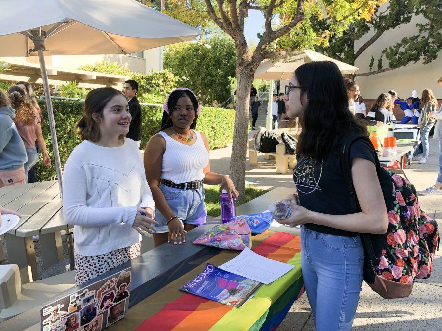 Alexandra Du Manoir 21 and Tabby Ayeni 21 encourage Grace Kosten 22 to join the Gender and Sexuality Awareness Club Oct. 21 during Community Service Week. Credit: Hannah Han/Chronicle