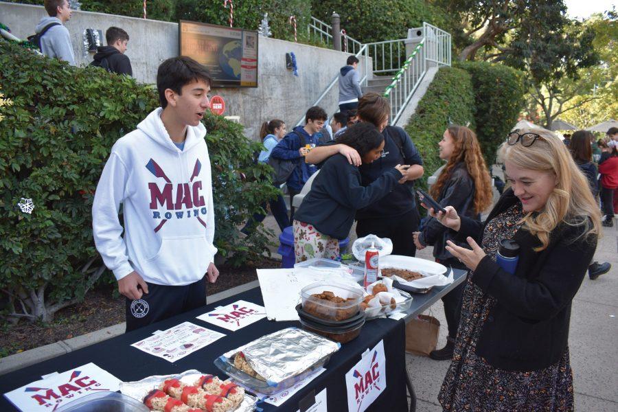 Upper School Dean Sharon Cuseo and Eli Friedman ’21 converse at the Winter Market on Dec. 2. In addition to selling food at the sale, many students chose to sell an assortment of goods, such as crocheted hats, handmade pottery and bracelets. Credit: Frank Jiang/Chronicle