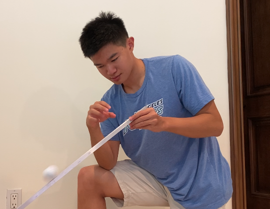 Peter Shen ’22 tries a classic physics experiment with materials sent by his teacher for his Honors Physics I class. This fall, many teachers are exploring creative ways to engage their students at home. Credit: Peter Shen, used with permission.