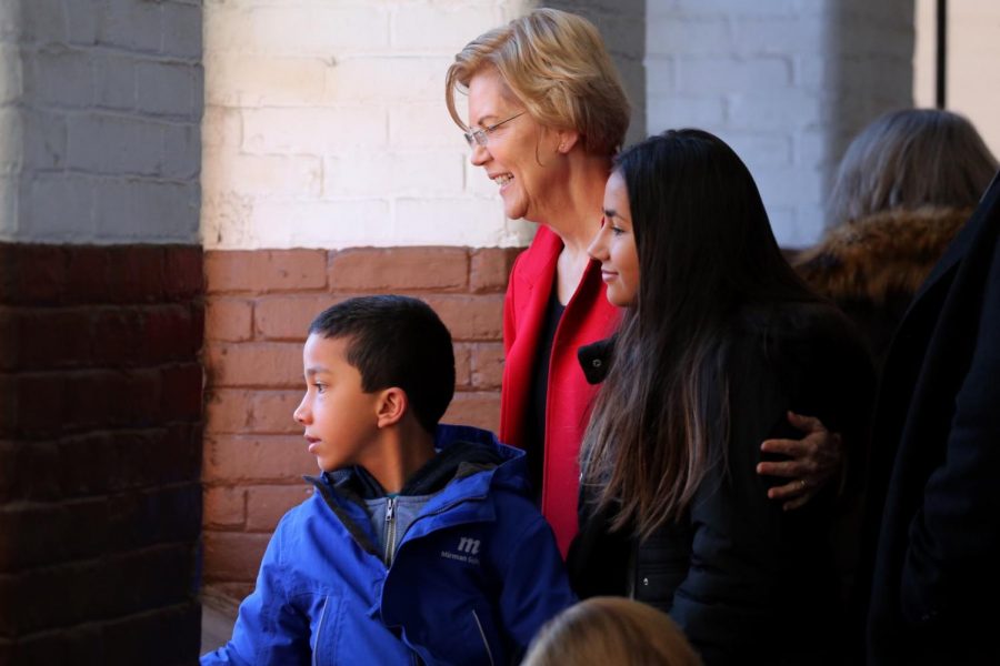 (From left to right) Atticus Tyagi, Senator Elizabeth Warren and Lavinia Tyagi ’23 embrace with a smile as they pose for a photo.
