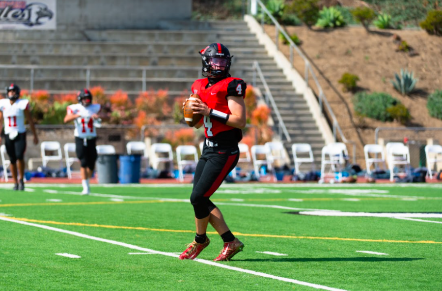 Quarterback Marshall Howe 21 warms up by throwing passes to his teammates before the scrimmage against St. Genevieve High School. 