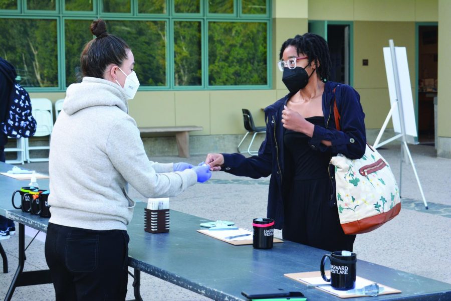 A Daily Dose: Chandace-Akirin Apacanis ’21 gives her nasal swab to Upper School Nurse Becca Pilgrim for pooled testing outside of the Munger Science Center in adherence with COVID-19 protocols before her class.