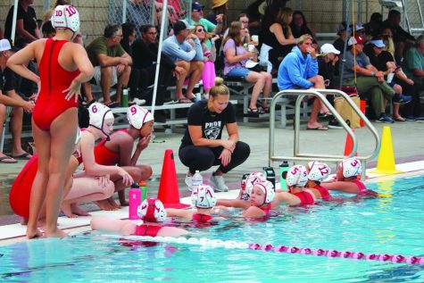 Gathering the troops: Pictured in black, new Girls Water Polo Program Head Jennifer Jamison leans over the pool during a time out to give feedback to players on her club team, Pride Water Polo Academy.