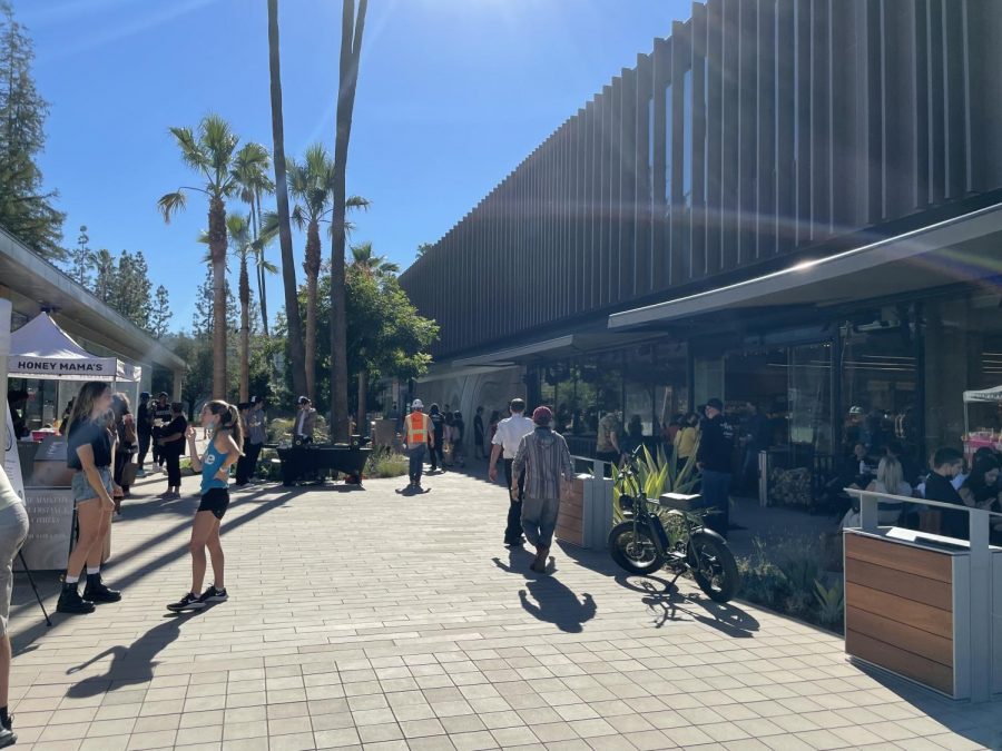 Crowds+rush+to+the+newly+opened+Erewhon+Market+on+Ventura+Boulevard+to+purchase+food+and+to+eat+at+their+tables+outside.+