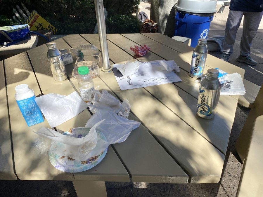 One table on the quad was left covered in plates, bottles, napkins and wrappers by a group of sophomores after a lunch period. The school is struggling to encourage students to throw out the trash they produce when they purchase their meals from the cafeteria.