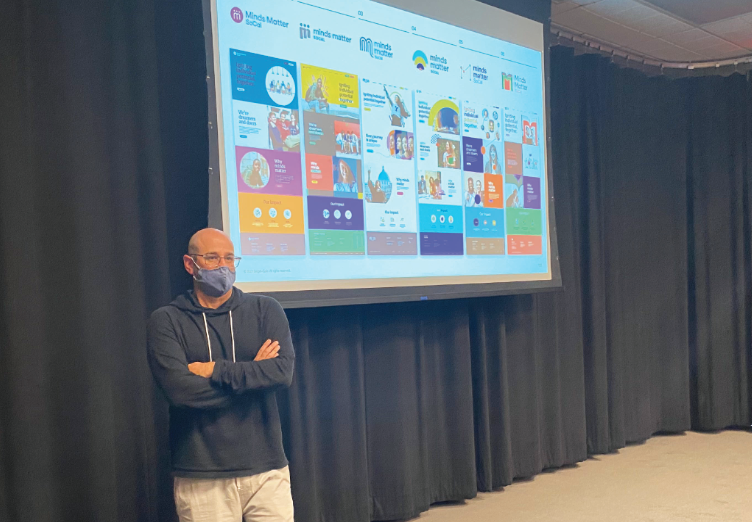 Jon Levine ’94 speaks to students about his nonprofit Minds Matter LA, outlining different potential logo designs and asking for their feedback as to which logos would best attract clients.
