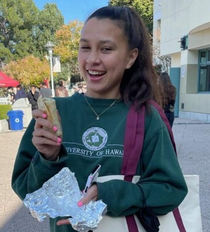 Daniela Quintero 22 smiles while holding a burrito from Poquito Mas, complimentary of the HWPA. 