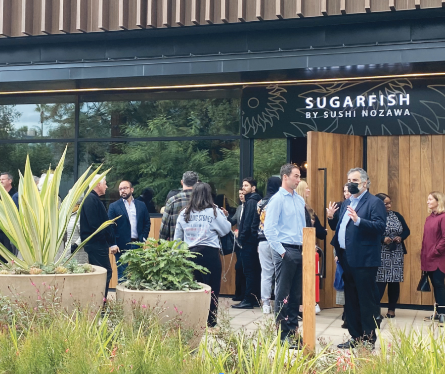 Patrons stand outside sushi restaurant SUGARFISH to witness its grand opening Dec. 9, chatting as they wait in line to try the Japanese cuisine. 