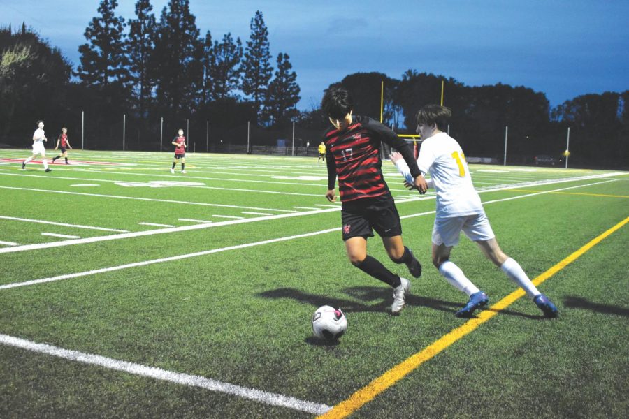 ROAD RUNNER: Left-back Ollin DeAntonio ’22 dribbles past a defender in boys soccer’s match against Crespi Carmelite School on Jan. 14. The team won the game 6-0, with goals from Josh Barnavon ’24, Alejandro Lombard ’23, Wilson Federman ’24, Patrick Yeh ’23 and Theo Ottoson ’25. The team currently has a 9-3-3 overall record and a 4-1-1 league record.