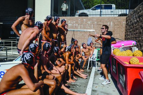 Boys Water Polo Program Head Brian Flacks gives feedback to his team during halftime.