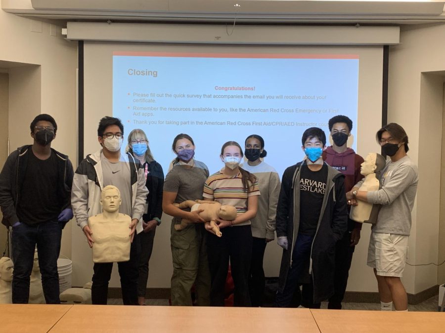 Participants in the Red Cross Clubs instructor training pose with the mannequins they used during the session to practice CPR.