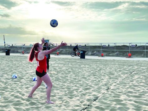 SERVING SUNSET: Maddie Hilboki 25 prepares to serve at a practice at Will Rodgers State Beach. The team holds a record of 3-1 this season.