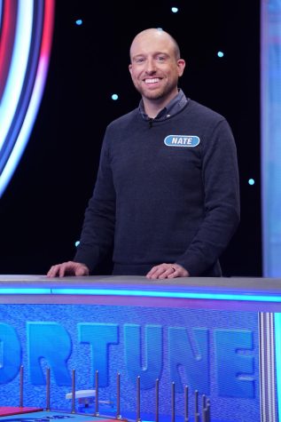 Science Teacher Cardin smiles as he works on solving a puzzle while competing on Wheel of Fortune.