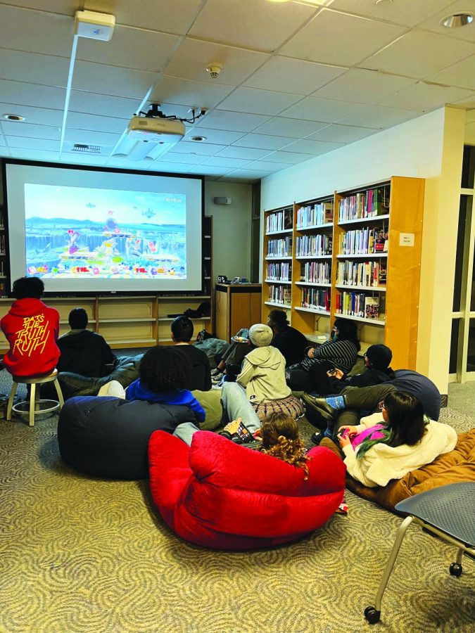 Staying for the Gaming: Students gather in front of a screen in Munger Library to play video games and socialize with fellow gamers. The game night also featured card games, board games, and Jackbox.