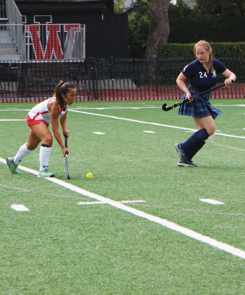 STICK IT TO THEM: Freshman Val Ganocy ’27 dribbles the ball up the field with her stick, looking to get around a Newport Harbor defender.