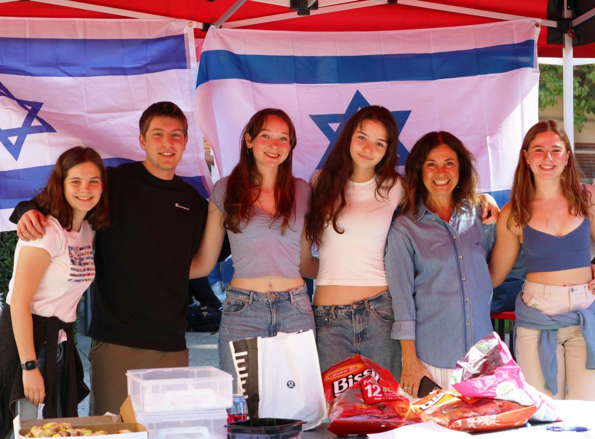 Jewish Club leaders and members stand together at their table. The club organized a public fundraiser for Magen David Adom, a medical organization, that took place on the Quad on Oct. 19 and Oct. 20.