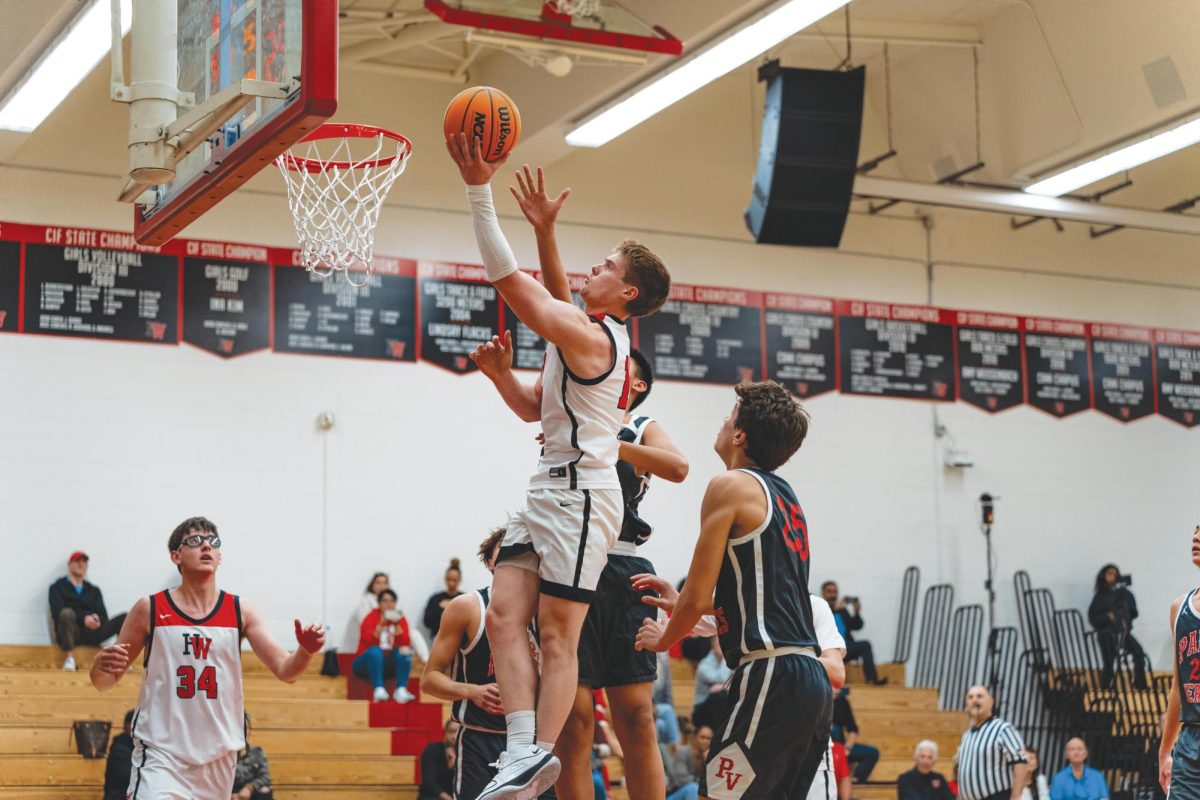 IN HIS BAG: Wing Niccolo Kalischer-Stork 24 drives through two defenders to the basket to score a layup. In a game  against John Burroughs High School on Nov. 29, the Wolverines beat the Bears 88-47 in Taper Gymnasium.