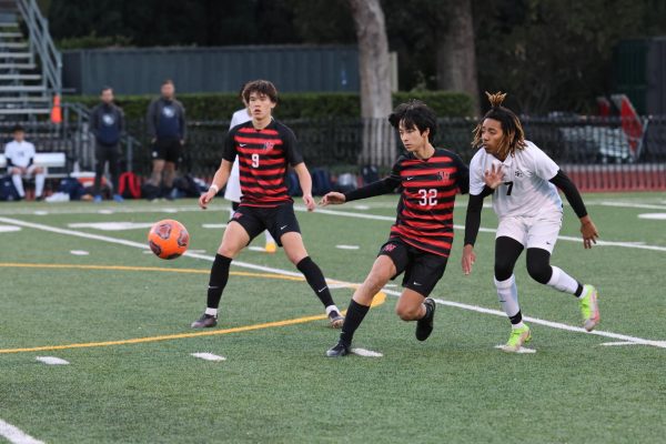 Midfielder Kevin Chen 25 looks to maintain possession of the ball against a defender in a game against Cathedral High School on Dec. 2.