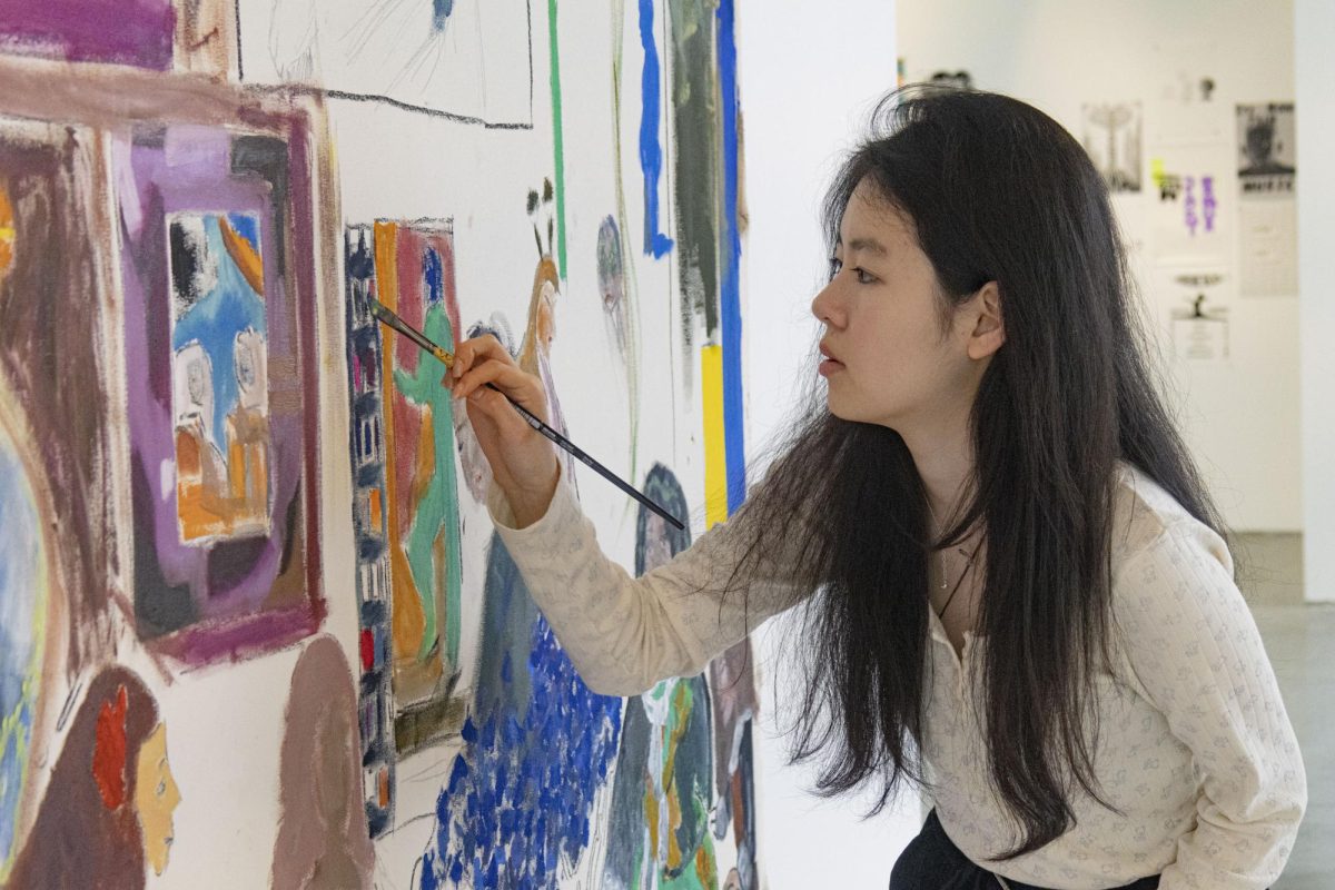 Lisa Suen, a foreign exchange student from the World Leading Schools Association in Shanghai (WLSA), paints on a collaborative canvas installed in Feldman-Horn Gallery. Suen, a junior, is one of the six students the school hosted from Jan. 22 to Feb. 22.