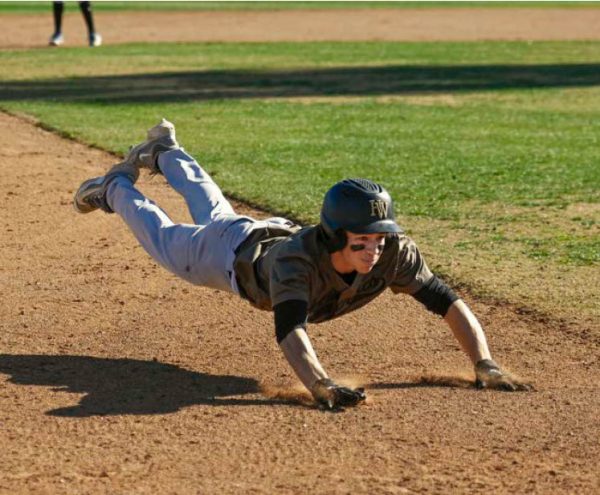 Outfielder James Tronstein 26 looks to make a headfirst slide in a preseason game.