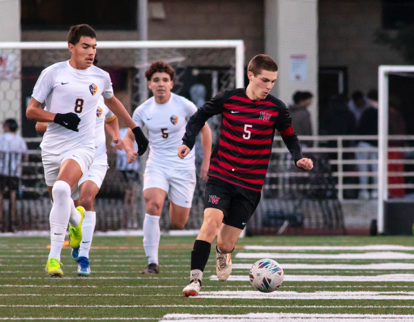 Senior midfielder Spencer Casmassima 24 advances the ball up the pitch in a playoff match against Millikan High School.