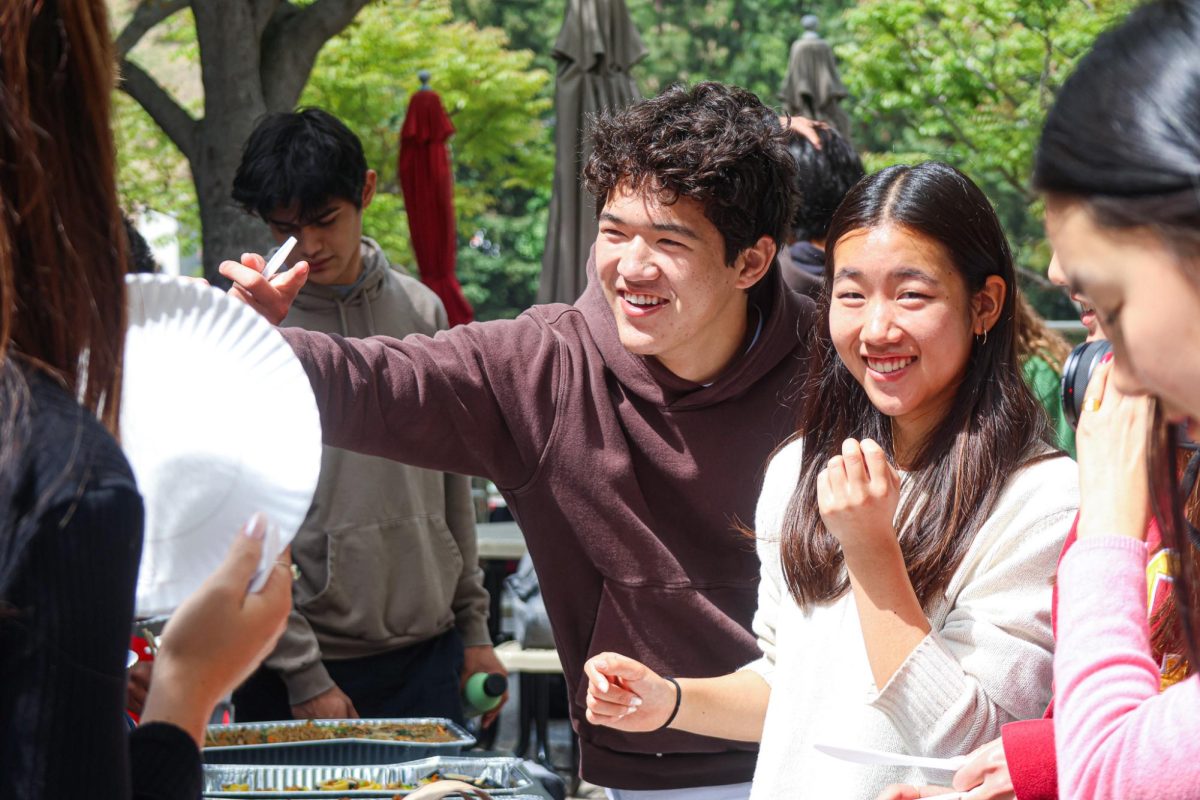 Members of Asian Students in Action (ASiA) hand out prepared food on the Quad during the annual Multicultural Fair. Several affinity groups were present and shared cultures and food with the community.