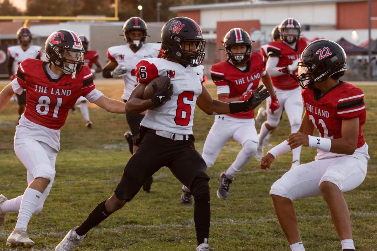 Wide receiver Elijah Williams ’25 braces for a tackle after a reception in a game against Cleveland Magnet High School