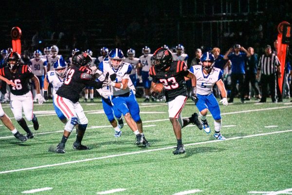 Running back Kurtis Walter '27 runs the football after a snap against the Palisades defense. The Wolverines fell 30-13 in the home game against Palisades Charter High School.