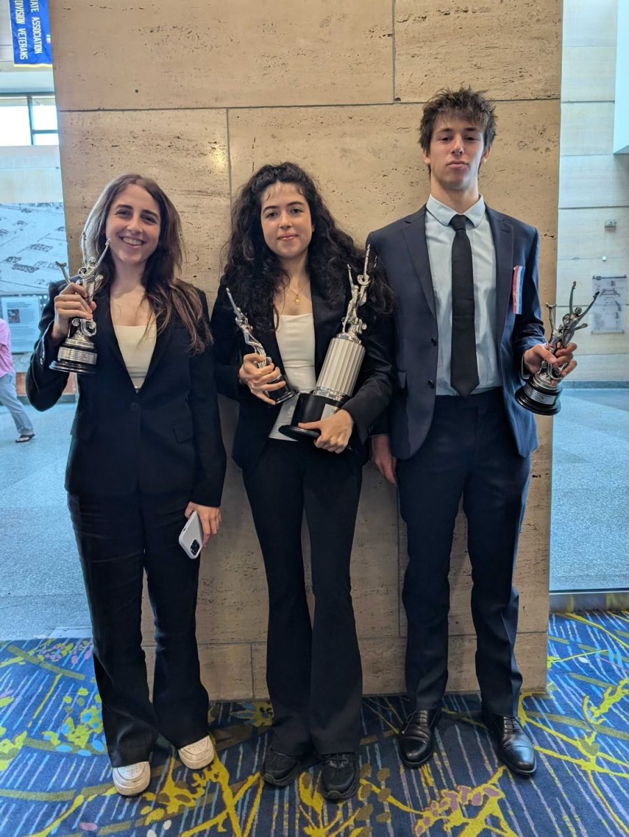 Worlds Debate team members pose for a photo with their trophies for placing fifth in this year’s NSDA National Tournament.