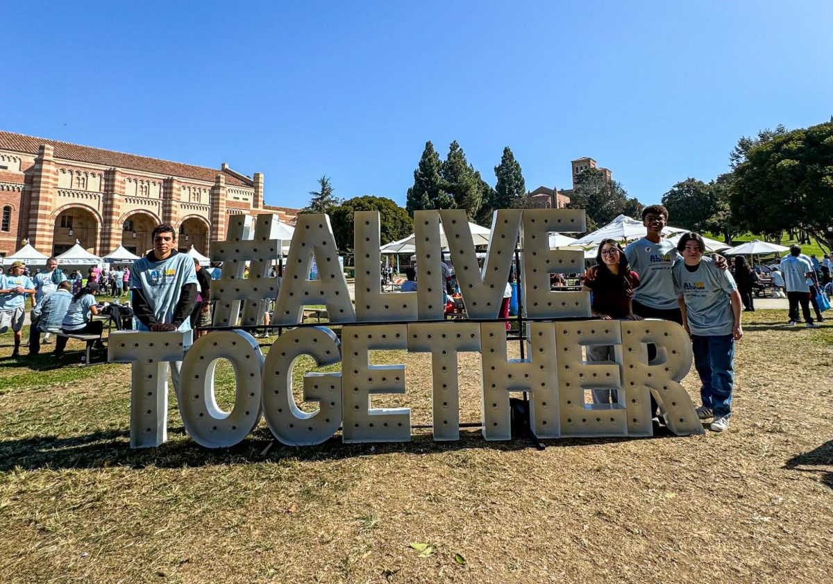 Students stand at an Alive Together sign at Wilson Plaza in Westwood. The school's cohort joined others to march for suicide prevention and awareness.