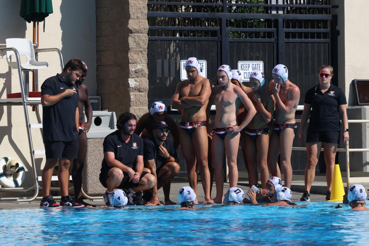 Head coach Jack Grover regroups with the team during a timeout with a team huddle