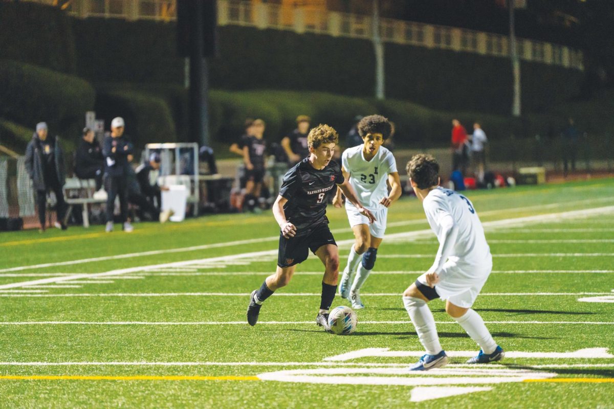 ON THE ATTACK: Roen Beiley ’25 maneuvers past defenders against Loyola High School during a home game. The team ended their season with a 9-5-2 record. They are now preparing for postseason playoffs.
