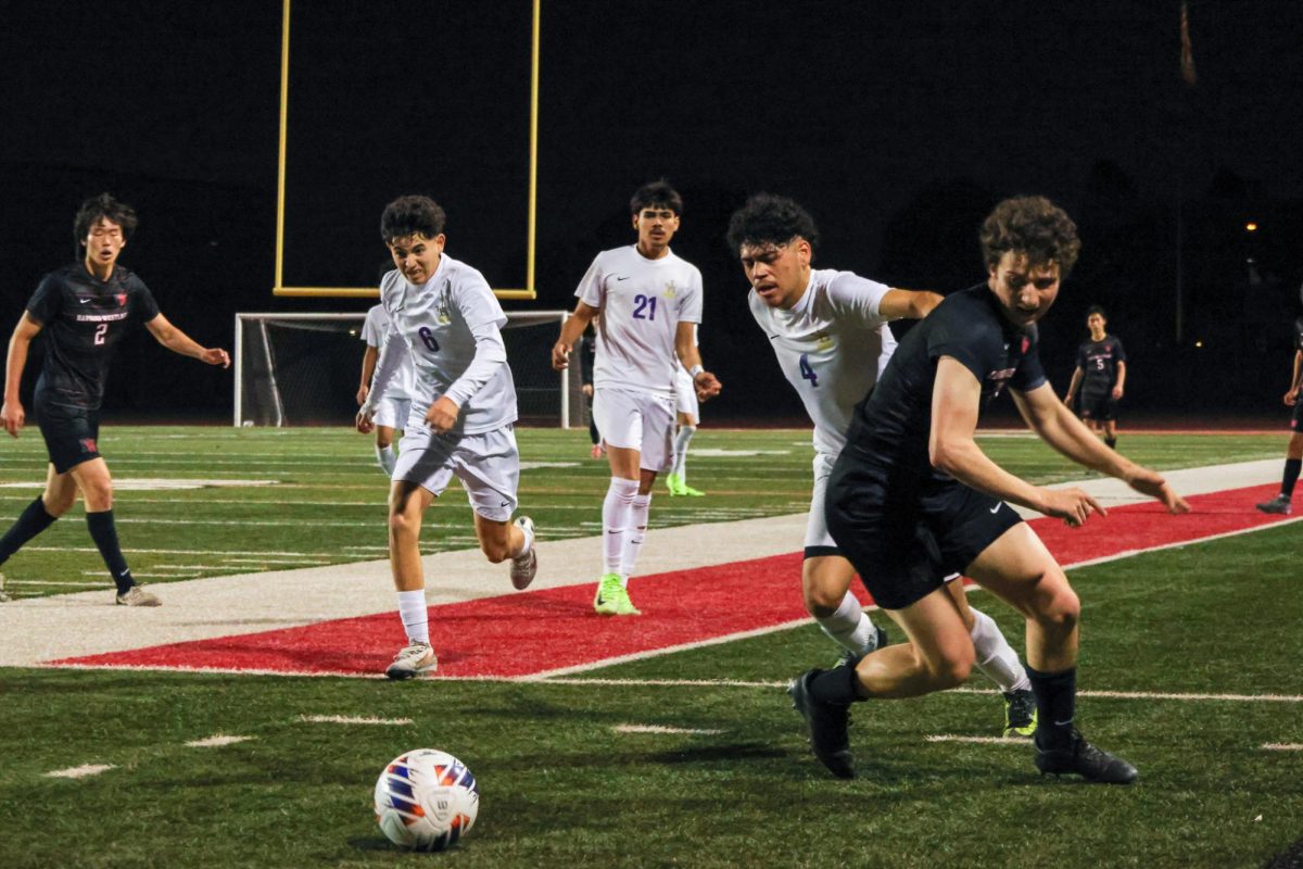 Striker Cole Grossman '25 fights over a ball with a Jurupa Hills defender.