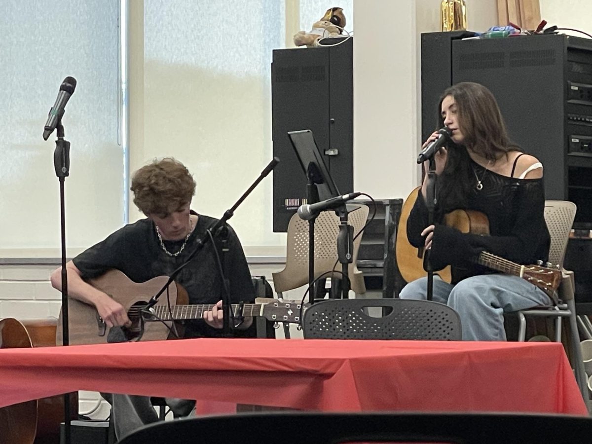 Student performers Nate Arnold '25 and Madeline Pimstone '25 play a song together at the Valentines' Day Coffehouse. Prefect Council organized the event and brought together various student performers.