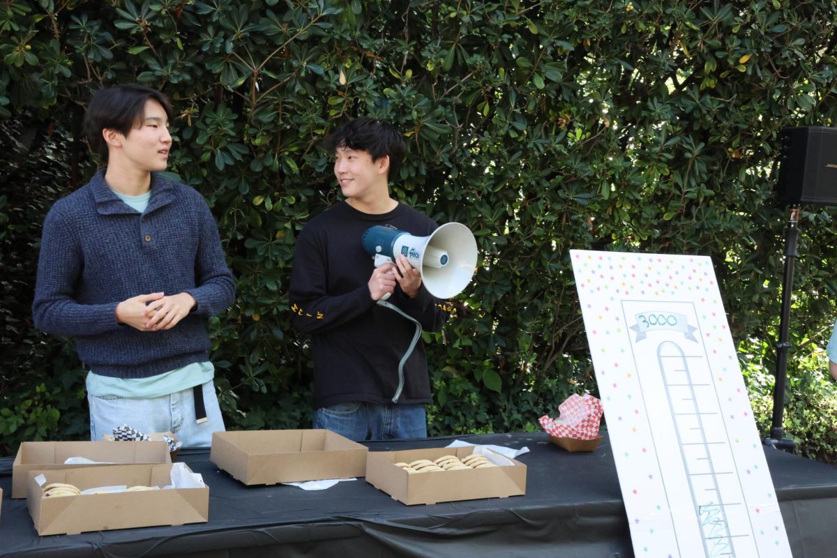Community Council members Collin Kim ’27 (left) and Max Lee ’27 (right) converse as they prepare to bring over any students and faculty wanting to support Angel City Sports. The fundraiser was held to raise money to purchase wheelchairs for athletes.