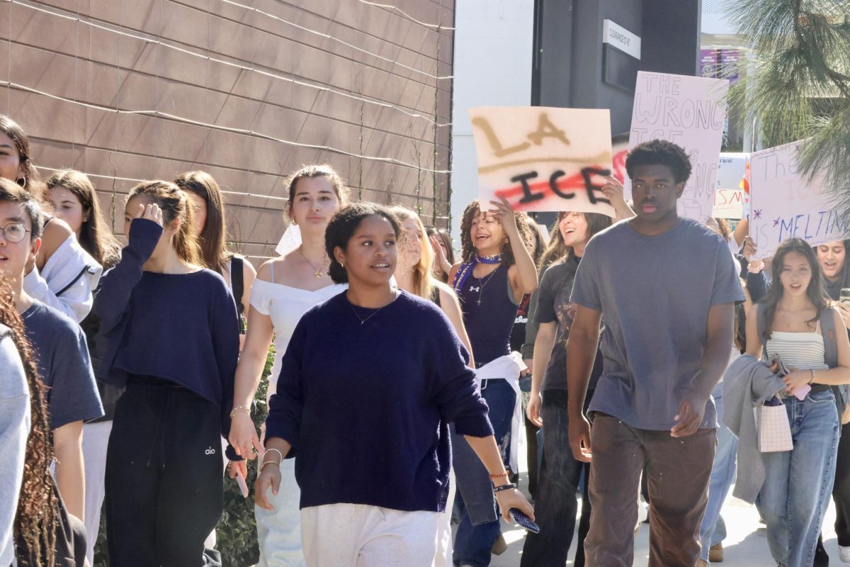 Students walk along Coldwater Canyon Avenue holding signs protesting the conduct of ICE in Minneapolis. The demonstration attracted attention from passing drivers as participants chanted various slogans deploring the organization.