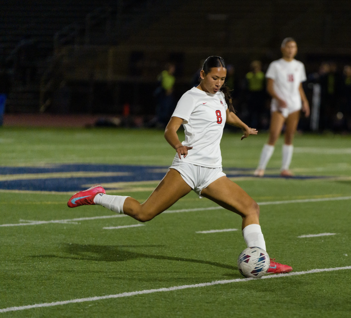 Defender Sabrina Puathasnanon '28 plants her foot, preparing to pass the ball to her teammate for a goal across the field.
