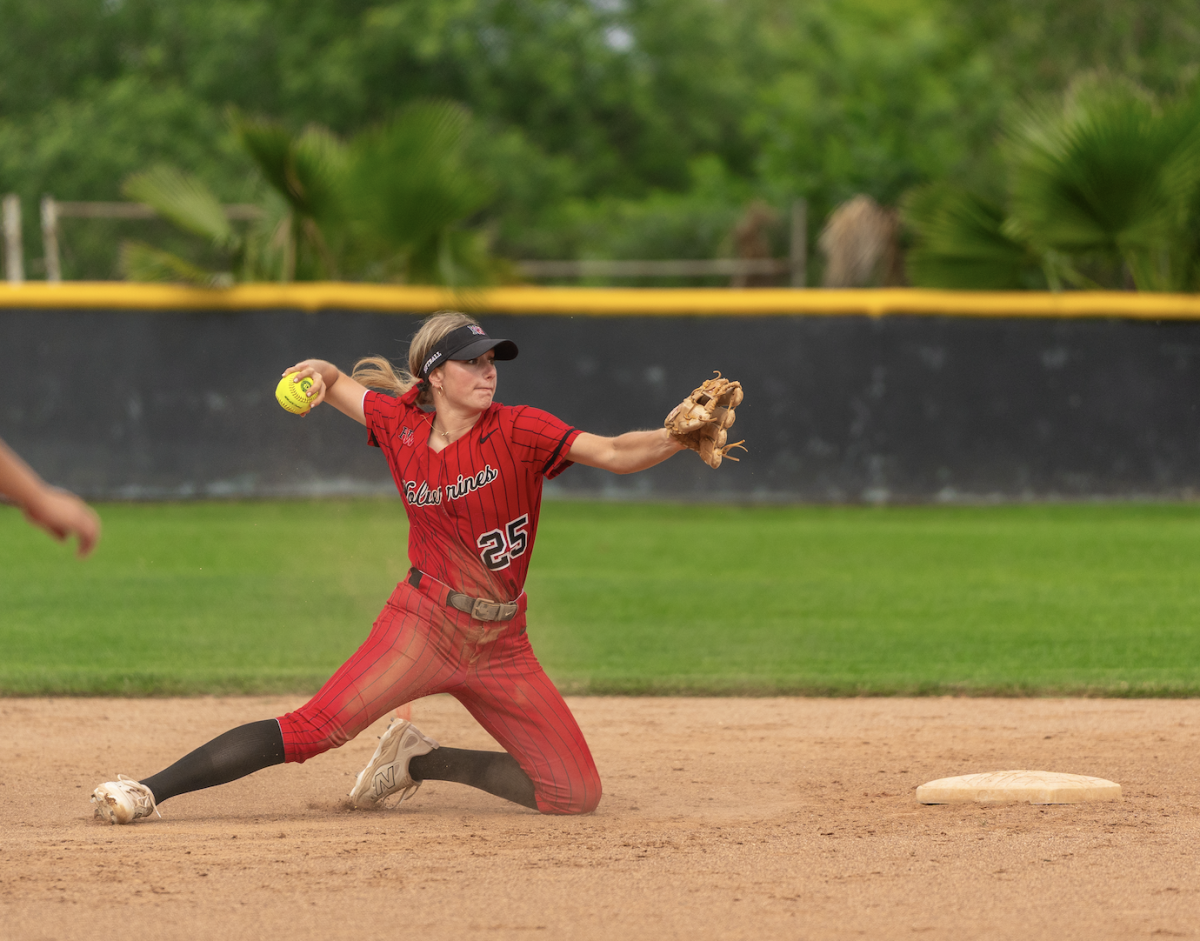 Catcher Dylan Fischer ’26 throws from the ground to first base during a game against Providence High School on April 9.
