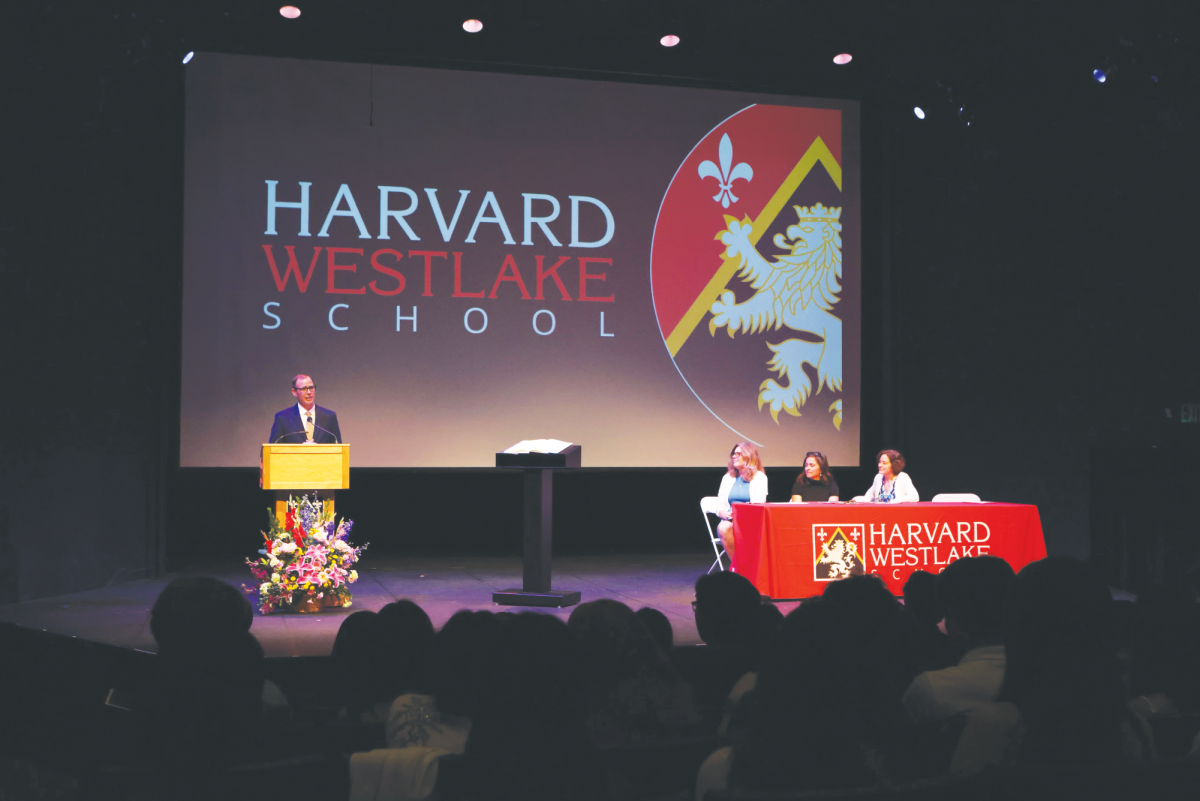 MARKING MERIT: President Rick Commons speaks at the podium during the Cum Laude ceremony as audience members watch. To the right sits Head of Upper School Beth Slattery, History Teacher and Cum Laude Chapter President Lilas Lane and Head of School Laura Ross.